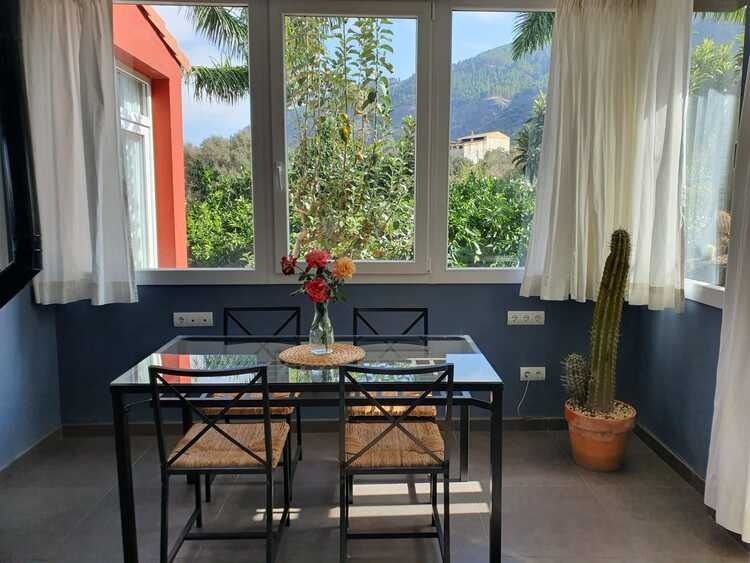 Un comedor con una mesa y sillas frente a una ventana.