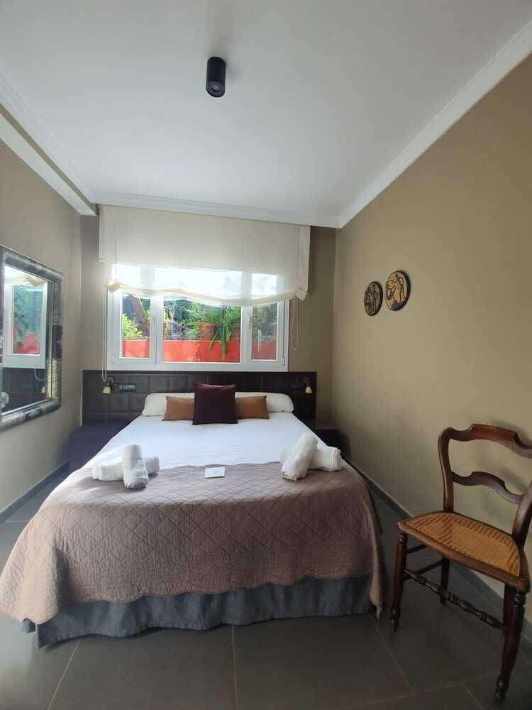 Un dormitorio con una cama grande y una silla.