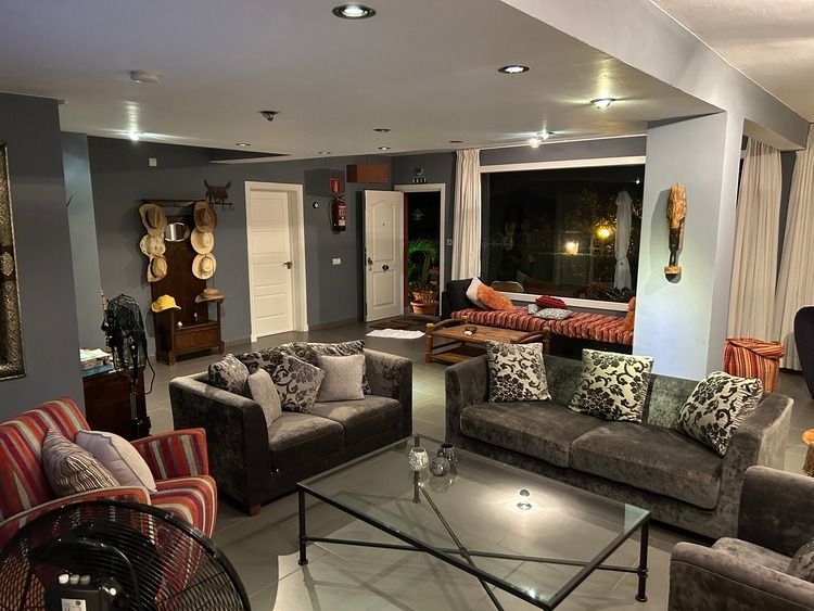 Una sala de estar llena de muebles y una mesa de centro de cristal.