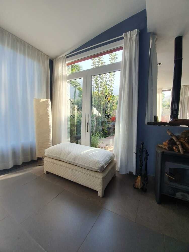 Una sala de estar con una otomana blanca y una chimenea.