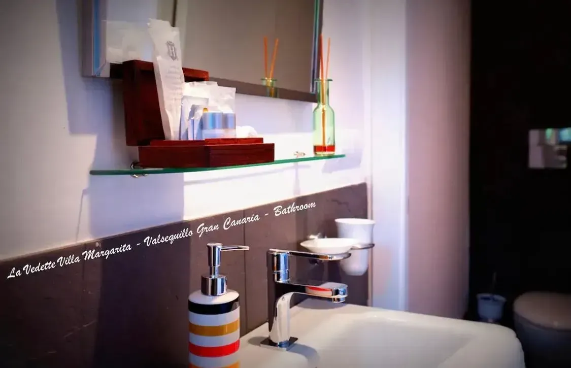 Un baño con lavabo, inodoro y espejo.