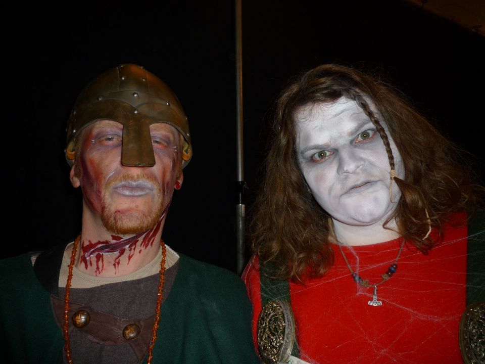 Ein Mann und eine Frau stehen mit bemalten Gesichtern nebeneinander.