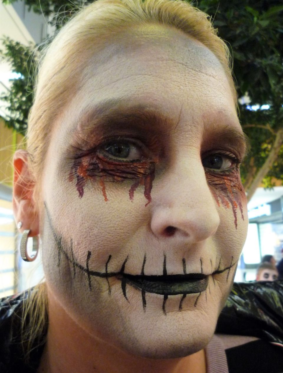 Eine Frau mit einem aufgemalten Skelettgesicht.