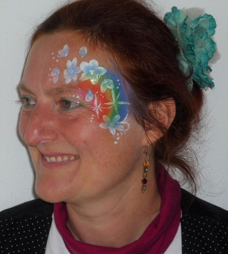 Eine Frau mit einem Regenbogen auf dem Gesicht