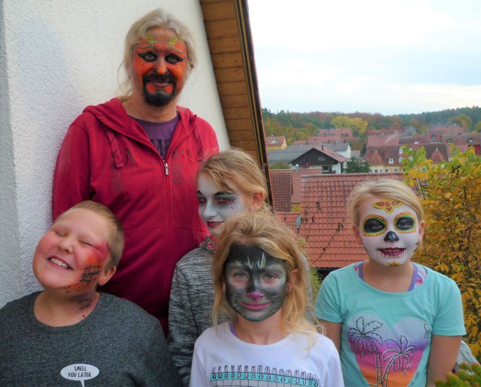 Eine Gruppe Kinder mit bemalten Gesichtern posiert für ein Foto.