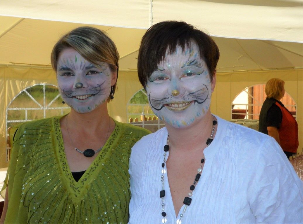 Zwei Frauen posieren mit bemalten Gesichtern für ein Foto