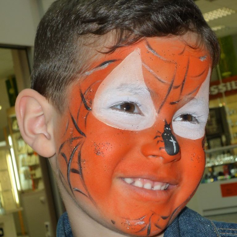 Ein kleiner Junge hat sein Gesicht so bemalt, dass es wie ein Fuchs aussieht