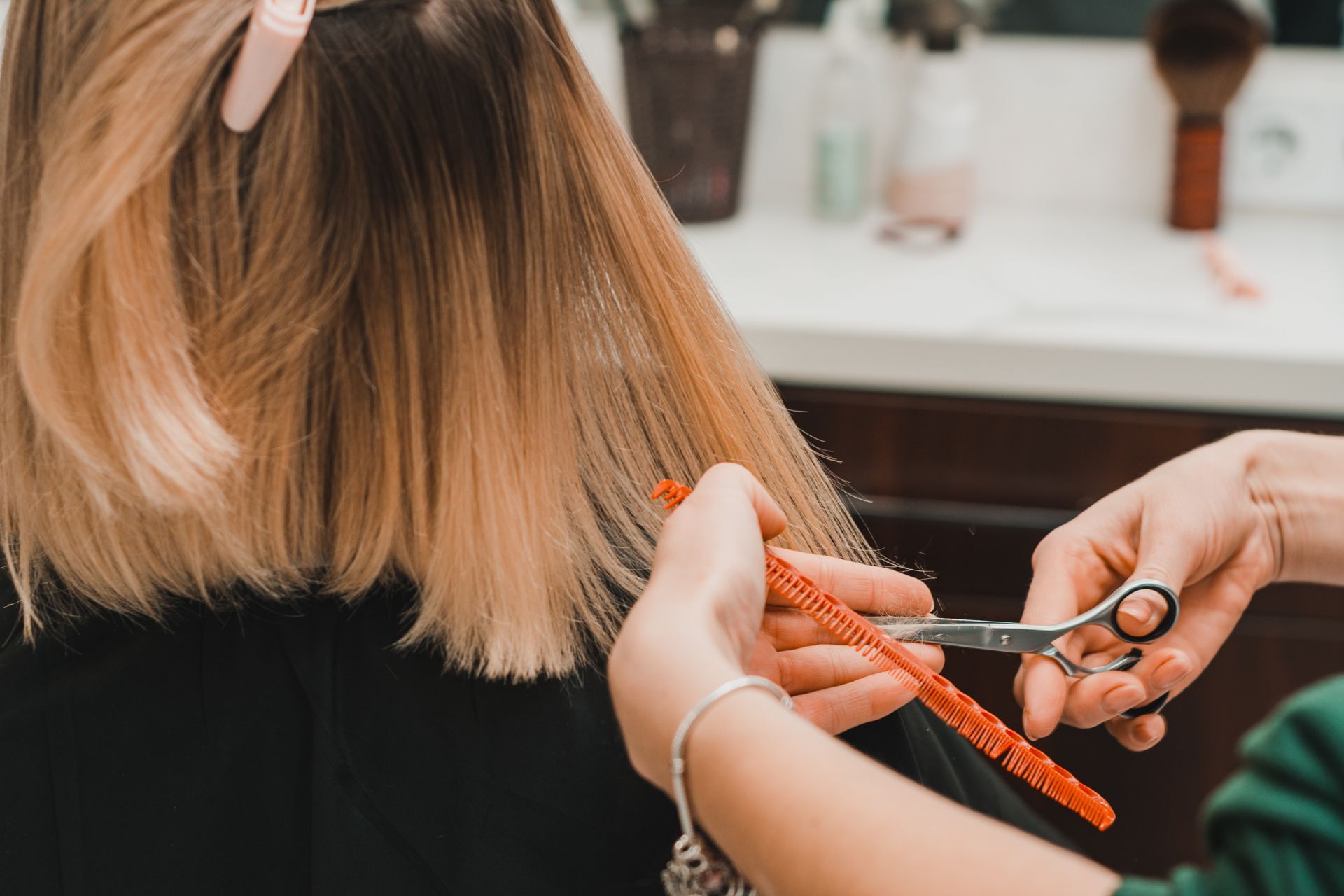 Friseur schneidet blonde Haare in einem Salon.