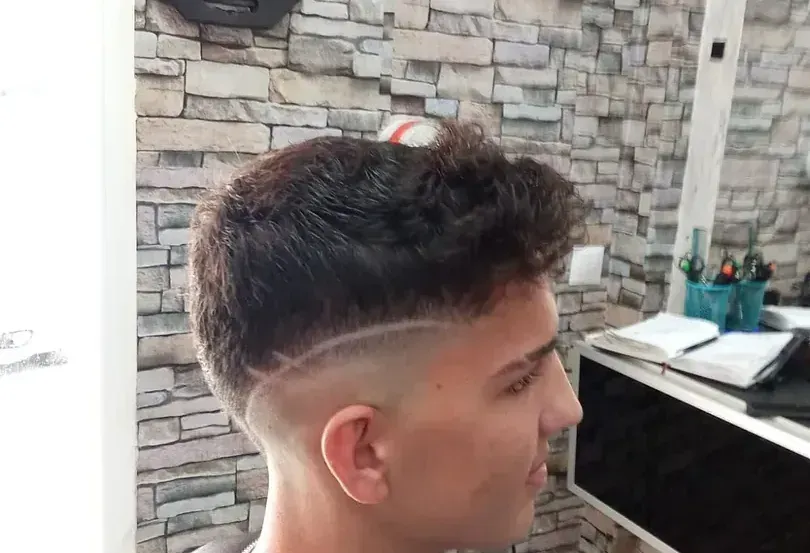 Un joven se está cortando el pelo en una barbería.