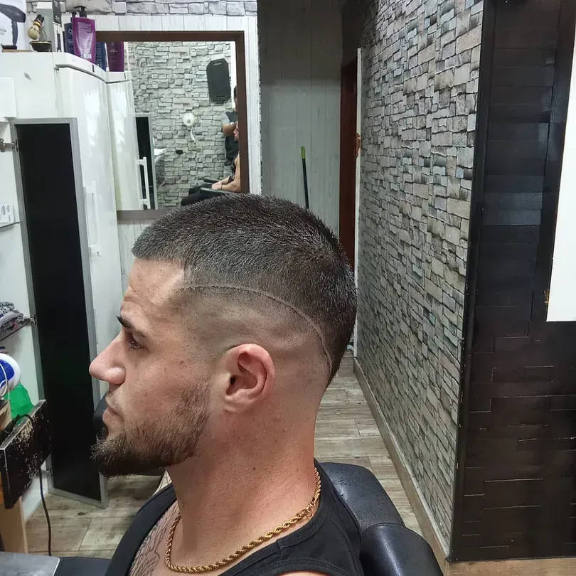 Un hombre con barba se está cortando el pelo en una barbería.