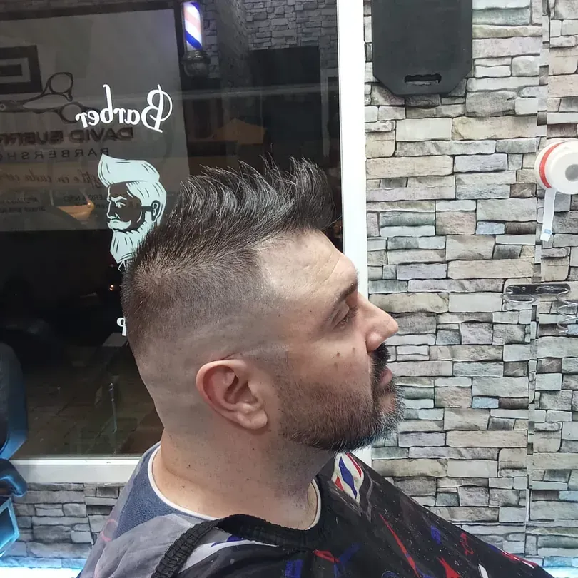 Un hombre en una barbería con un peinado mohawk.