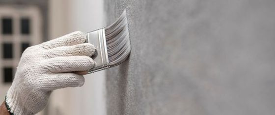 Mitarbeiter der Malermeister Wilhelm GmbH streicht Wand