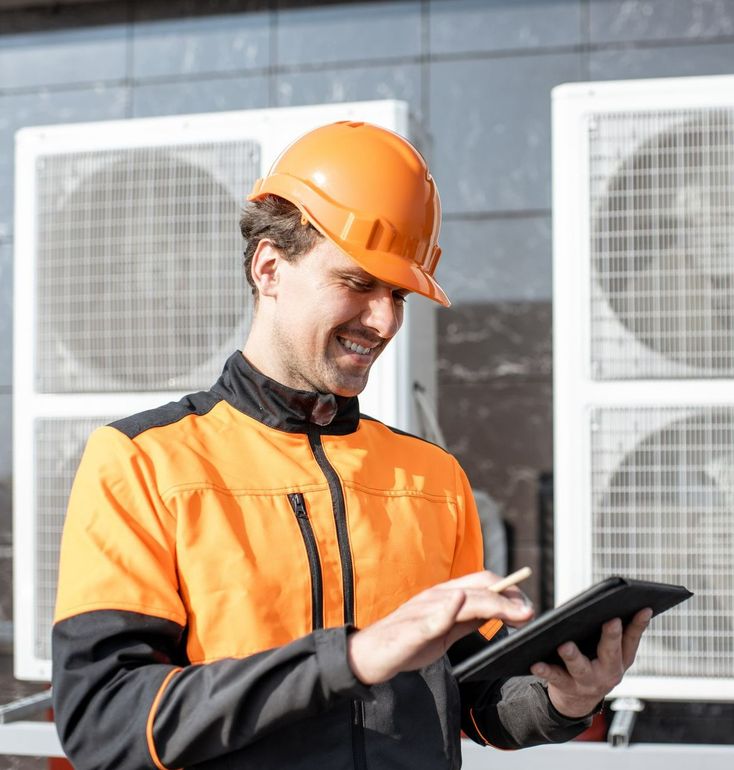 Technicien souriant avec un casque sur la tête et une tablette dans la main