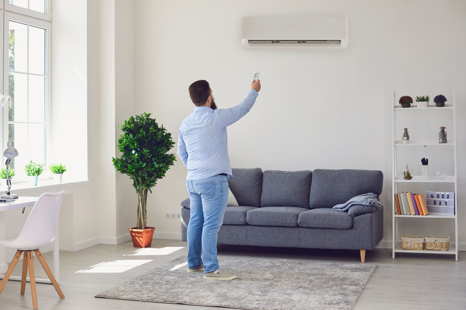 Homme allumant son climatiseur avec télécommande