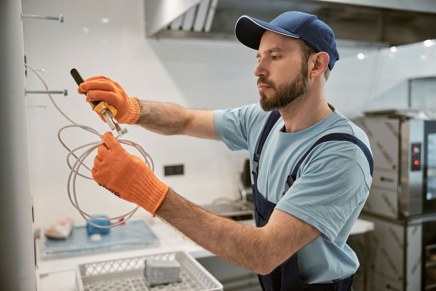 Mains gantées intervenant su un câble électrique avec une pince