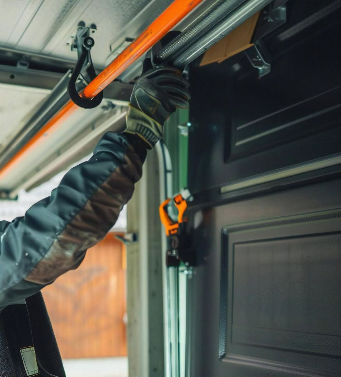 Mains gantées intervenant sur une porte de garage motorisée