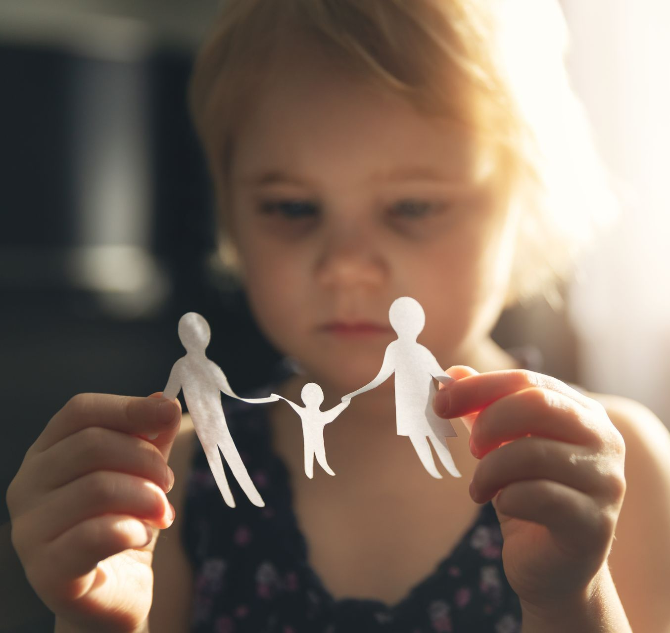 Un enfant avec une famille en papier dans les mains