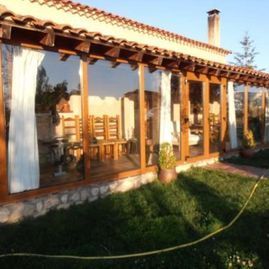 Una casa con muchas ventanas y una manguera delante de ella.