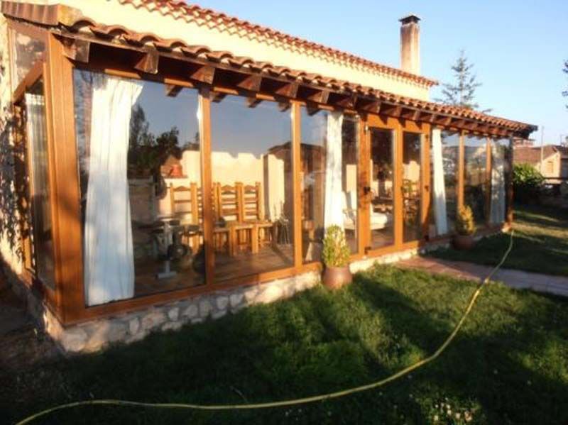 Una casa con muchas ventanas y una manguera delante de ella.