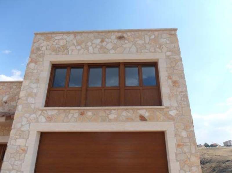 Un gran edificio de piedra con puerta de garaje y muchas ventanas.