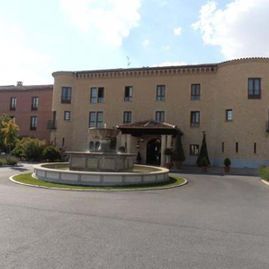 Un gran edificio con una fuente delante.