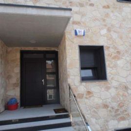 Un edificio de piedra con una puerta y escaleras negras.