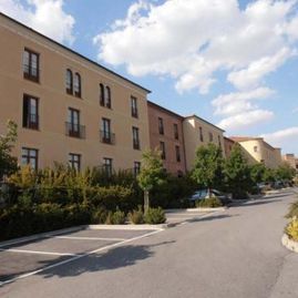 Una hilera de edificios con coches aparcados delante de ellos