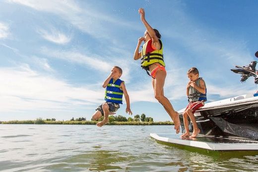 Kids jumping into Lake Conroe near our luxury vacation rental with pool and dock