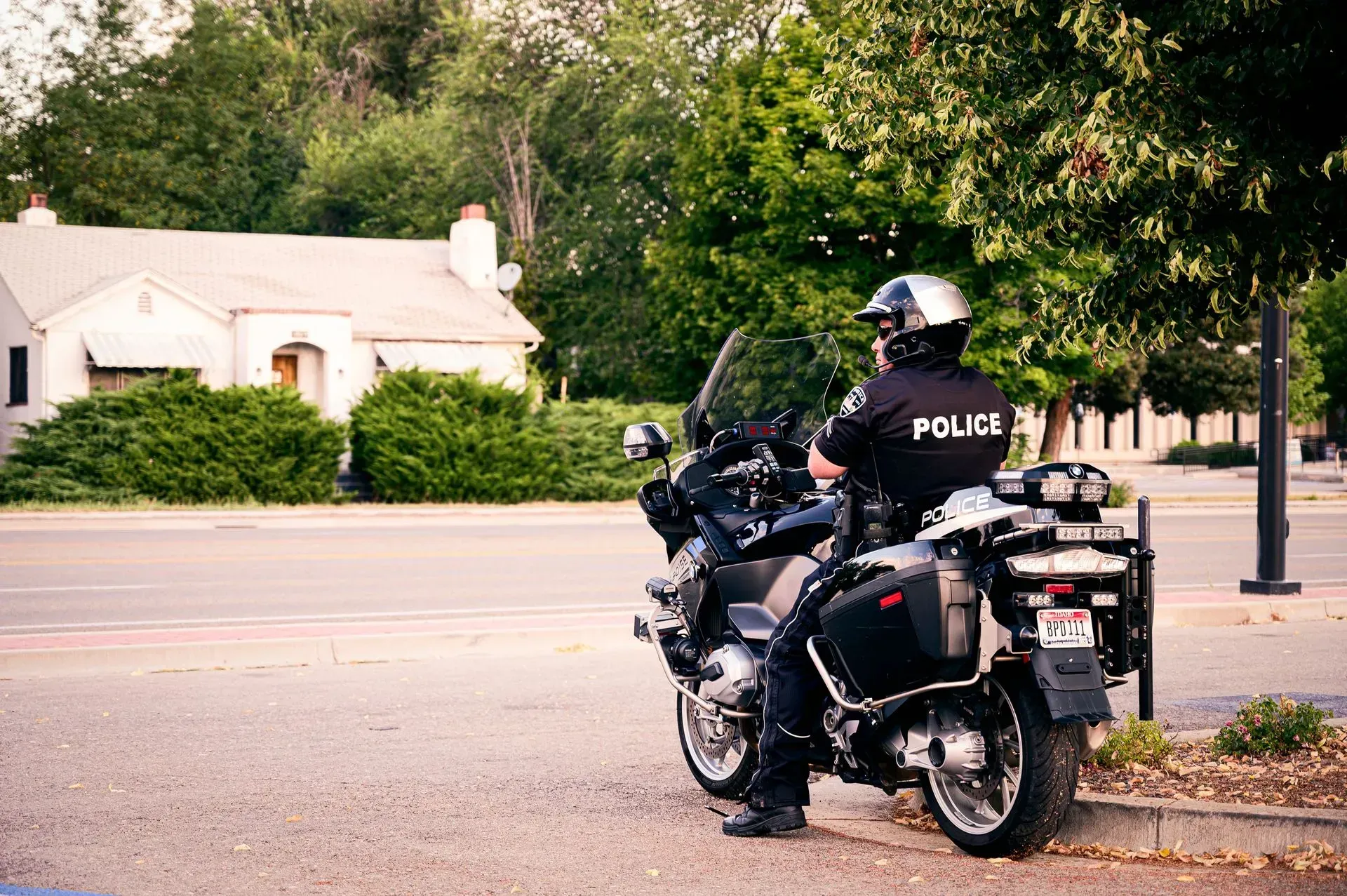 Ein Polizist fährt auf einem Motorrad am Straßenrand.