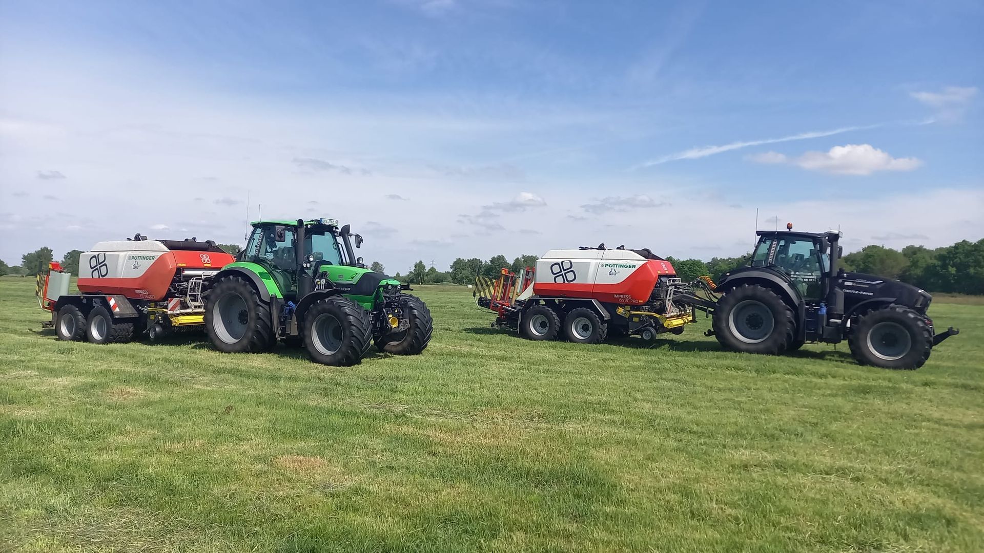 Drei Traktoren sind auf einer Wiese geparkt.