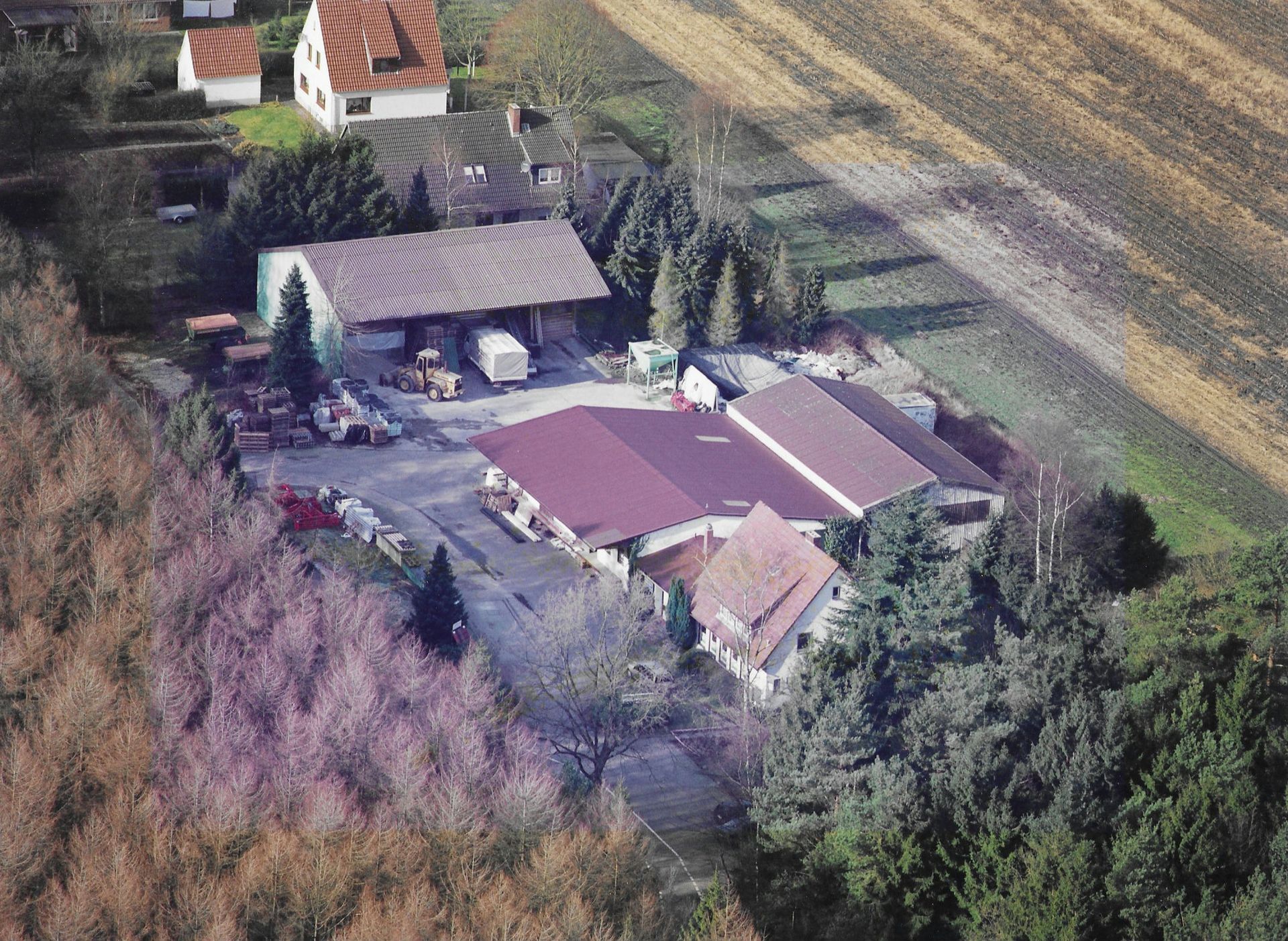 Eine Luftaufnahme einer Farm, umgeben von Bäumen und Feldern