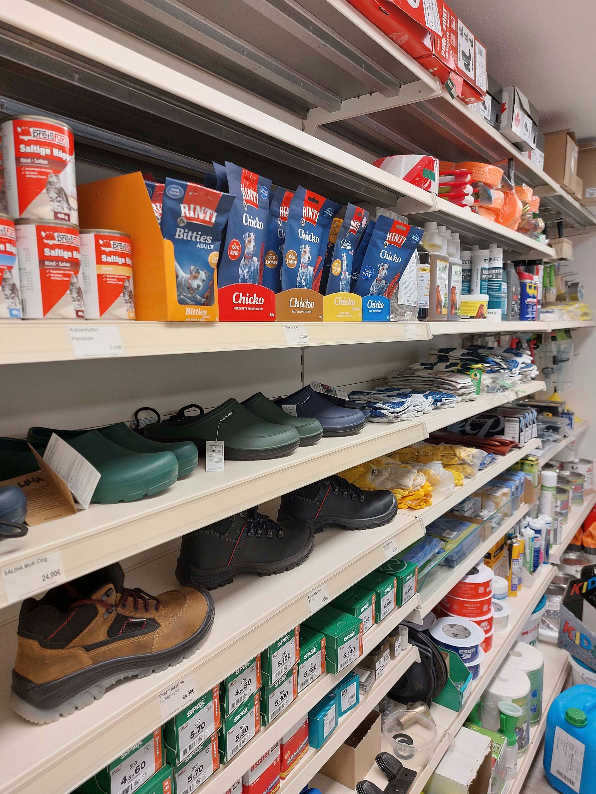 Ein Ladenregal voller vieler verschiedener Artikel, darunter auch Schuhe.