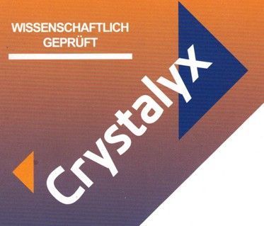 Eine schwarz-weiße Kuh liegt auf einer Wiese.