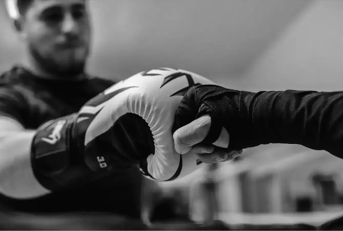 Pila de cuatro almohadas en tonos blanco, naranja y verde sobre un fondo beige.