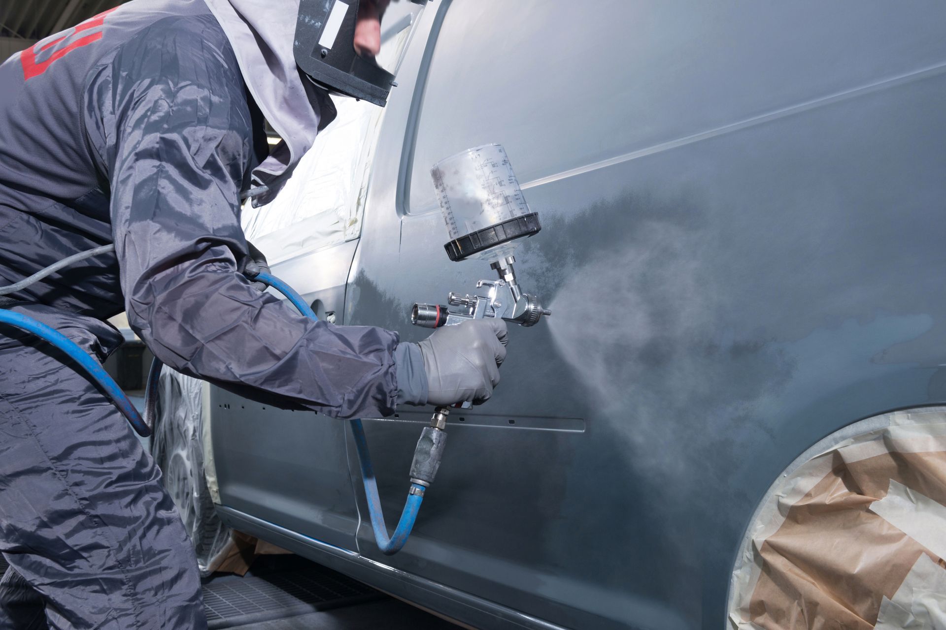 Un homme peint les plastiques de la carrosserie