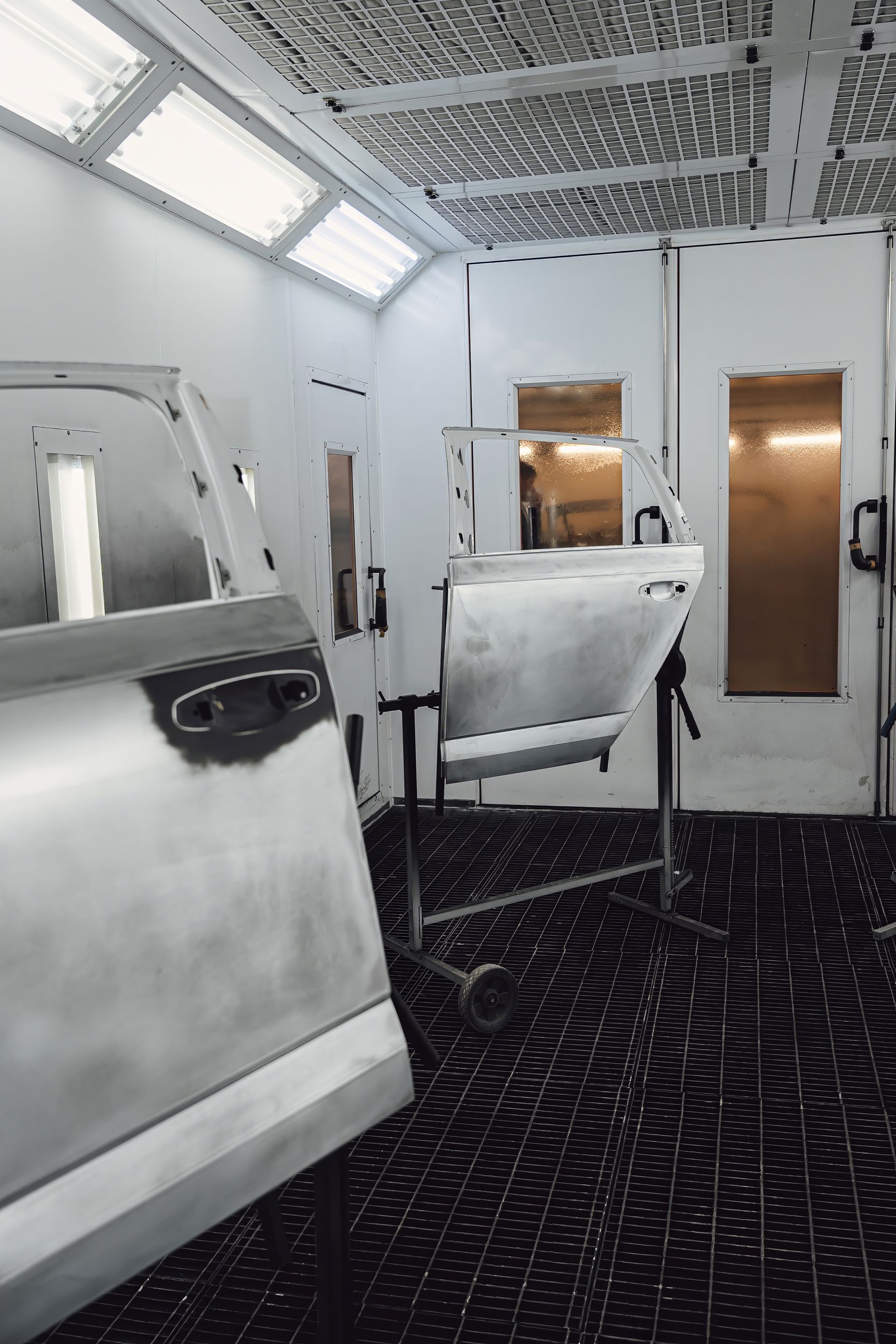 Des éléments de carrosserie d'une voiture dans une cabine de peinture