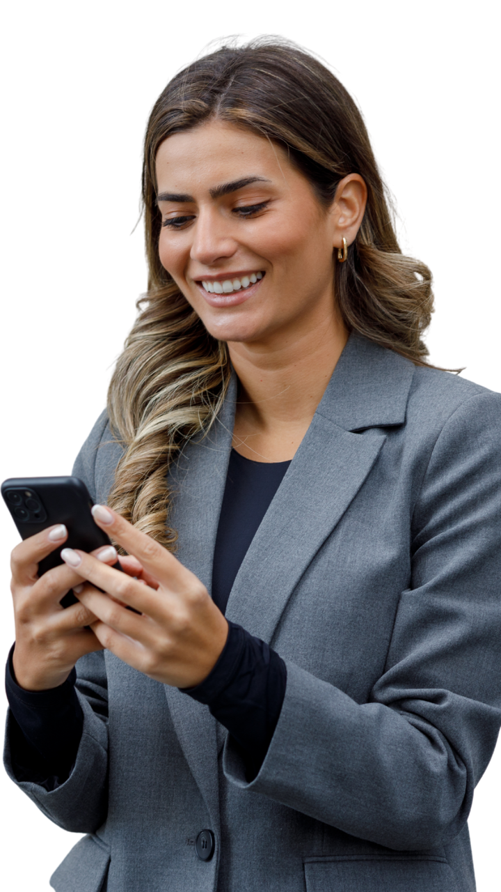 Femme en blazer souriante, regardant son téléphone.