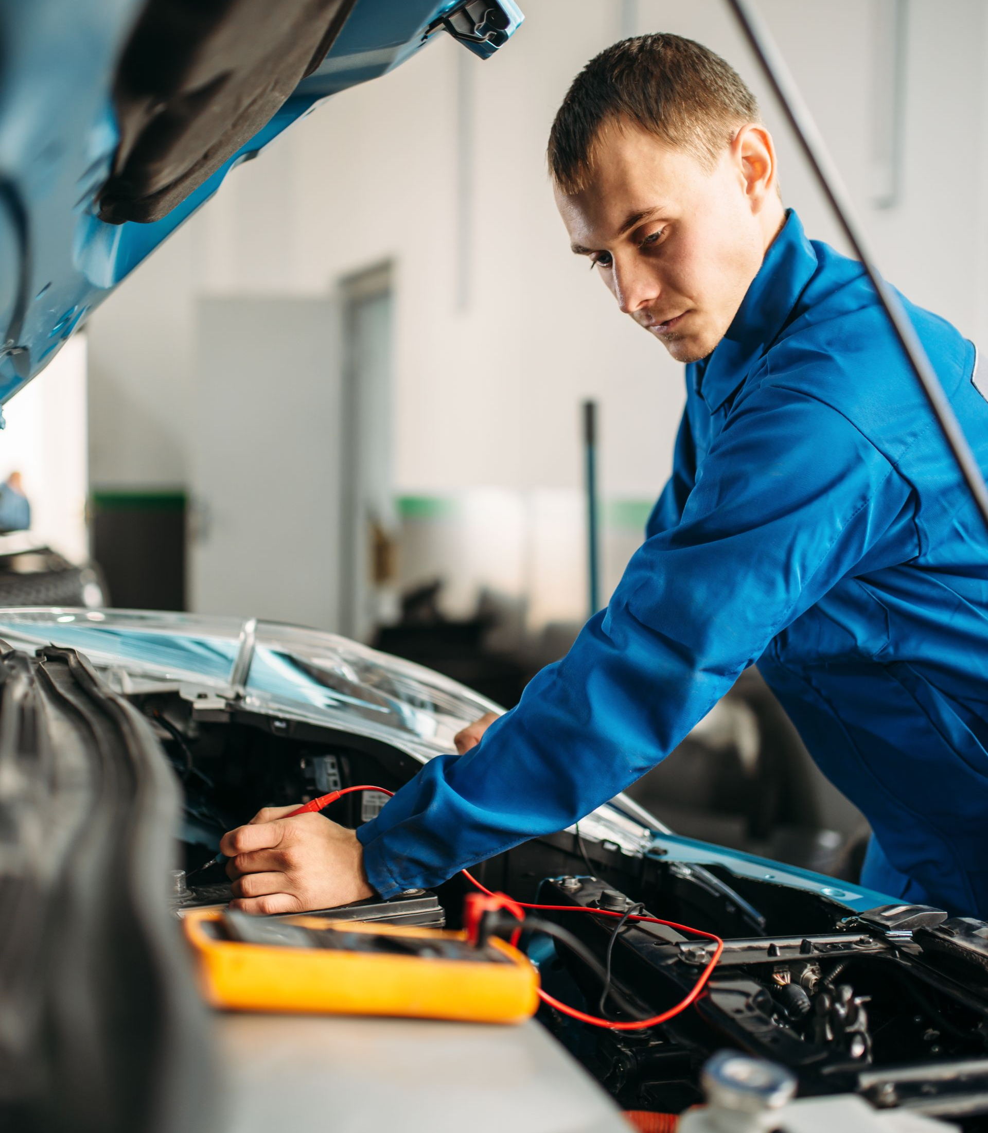 Un monsieur penché dans le moteur d'un véhicule