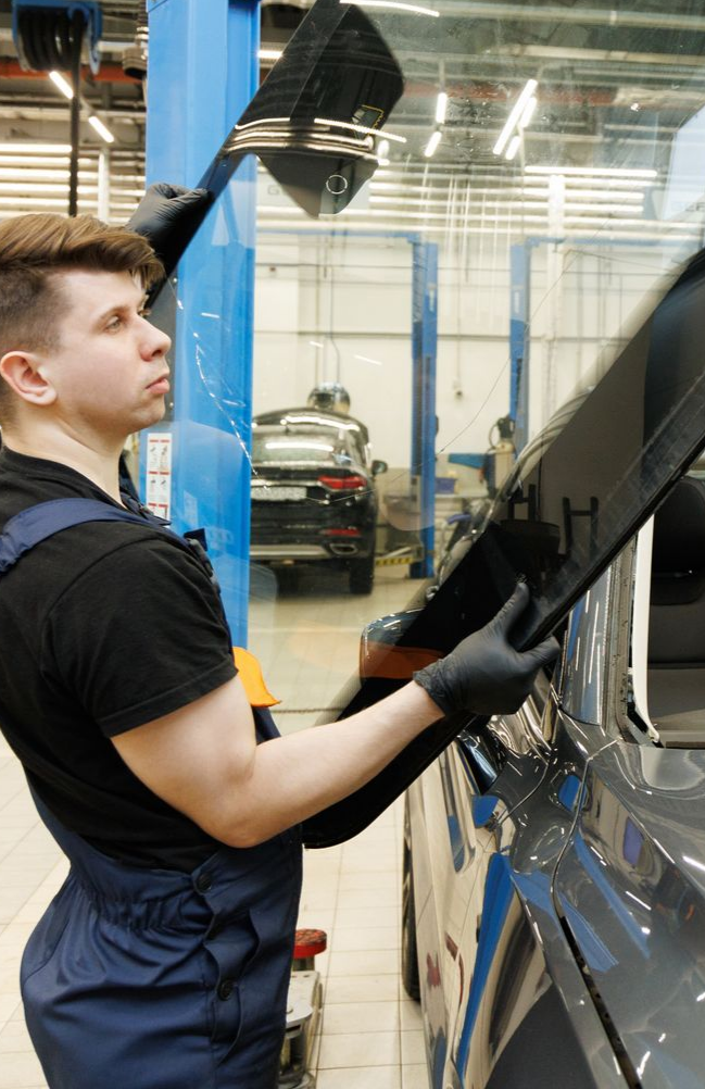 Un homme tient un pare-brise en latéral