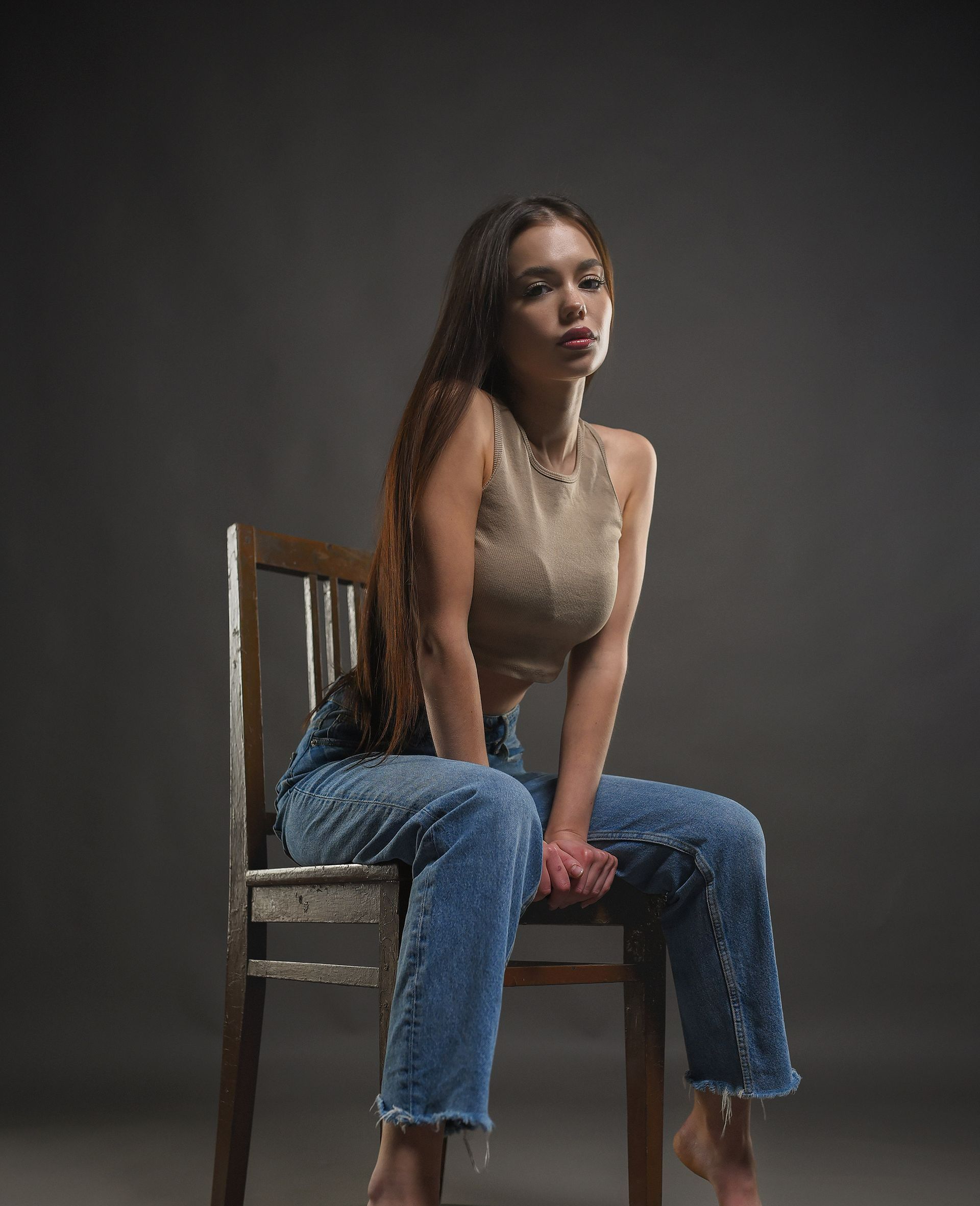 Femme posant sur une chaise.