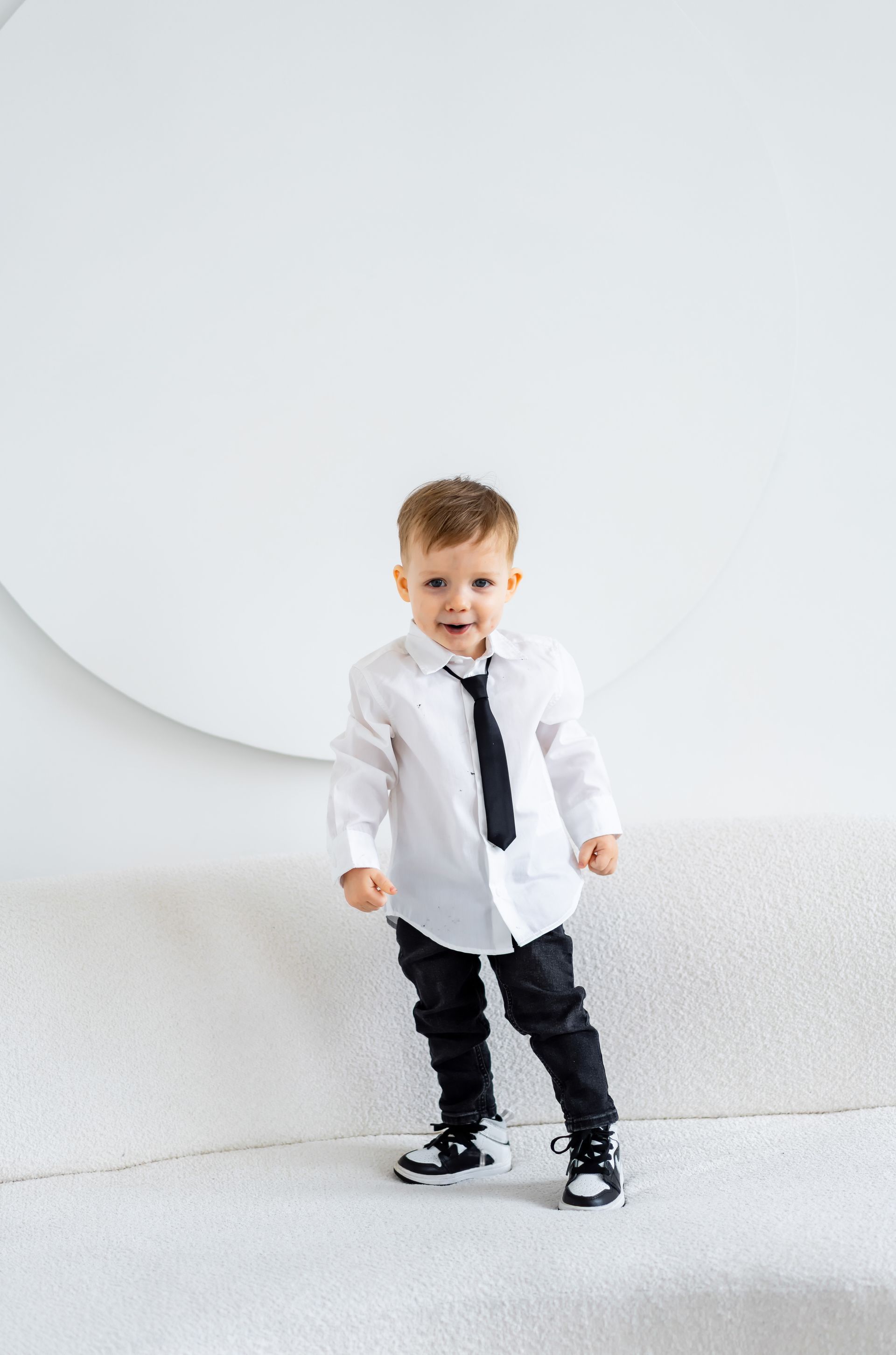 Un jeune garçon posant en chemise et cravate.