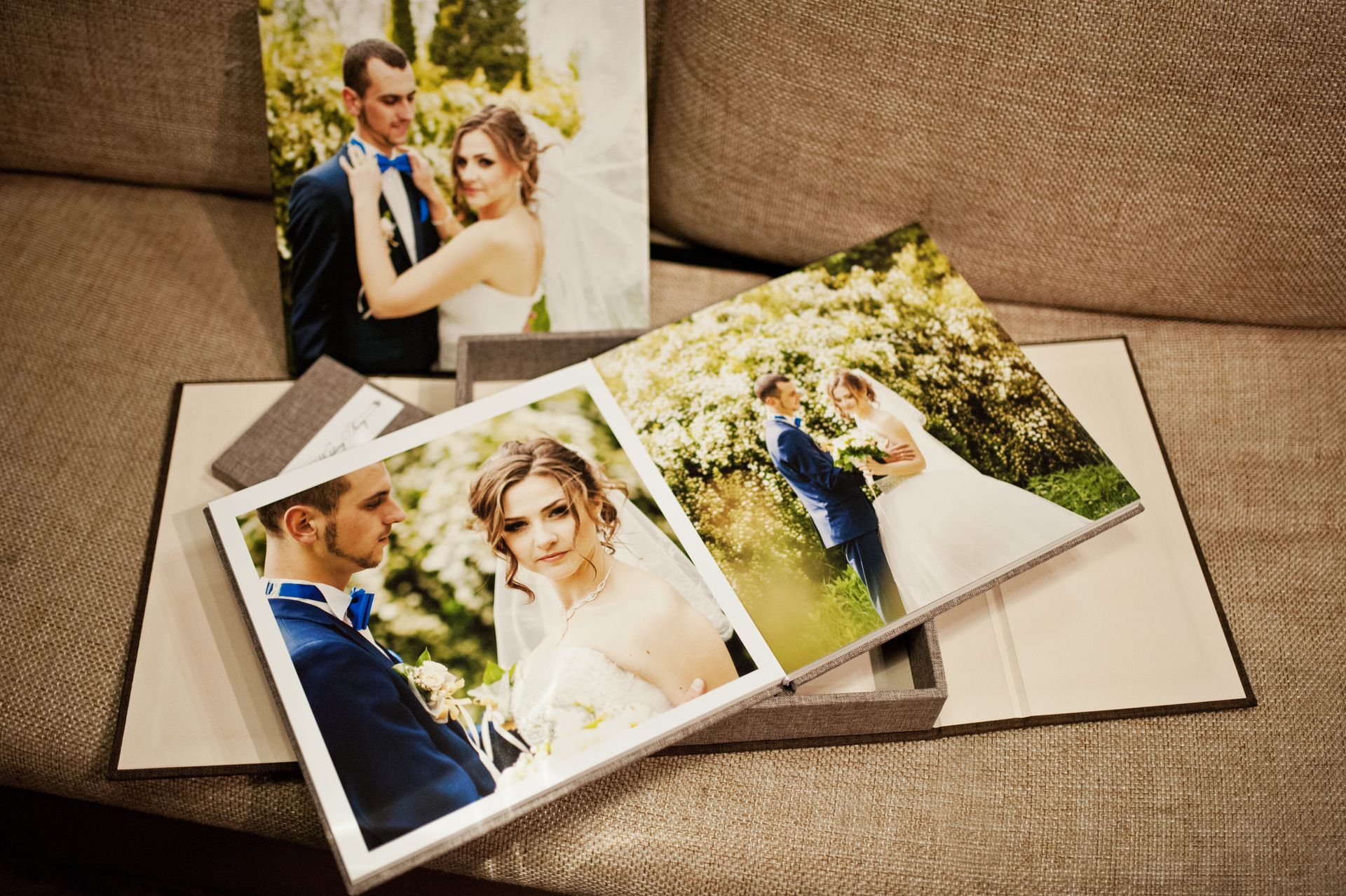 Album et photos de mariage posés sur un canapé en textile.