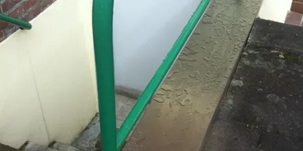 Eine Nahaufnahme eines grünen Geländers auf einer Treppe.Metallbau Vespermann