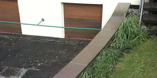 Ein Haus mit einer Garage und einem Zaun davor.