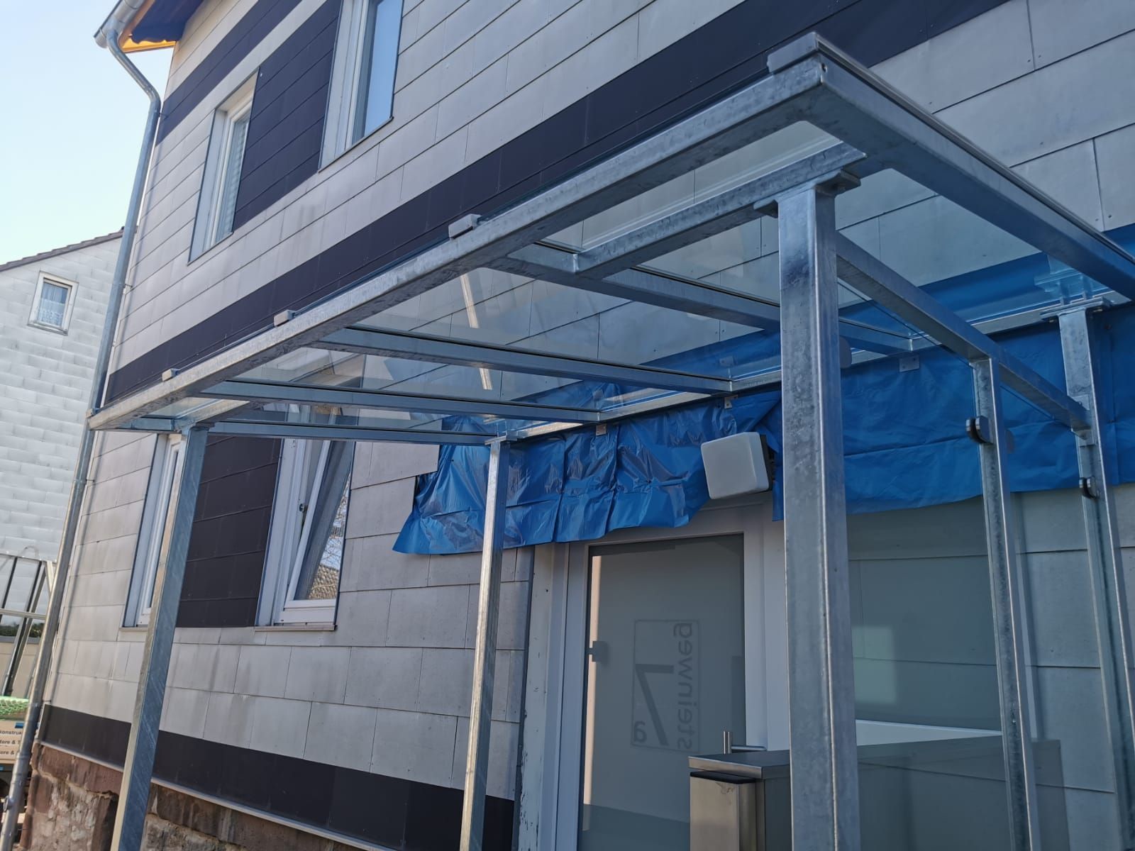 Ein Gebäude mit einem Glasdach über der Tür.