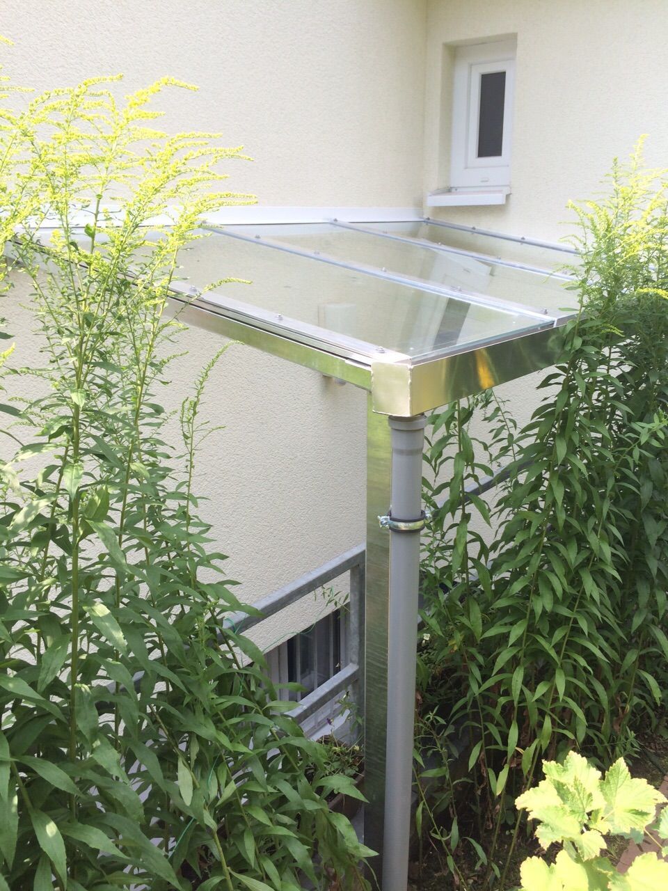 Ein weißes Haus mit einem Glasdach an der Seite.