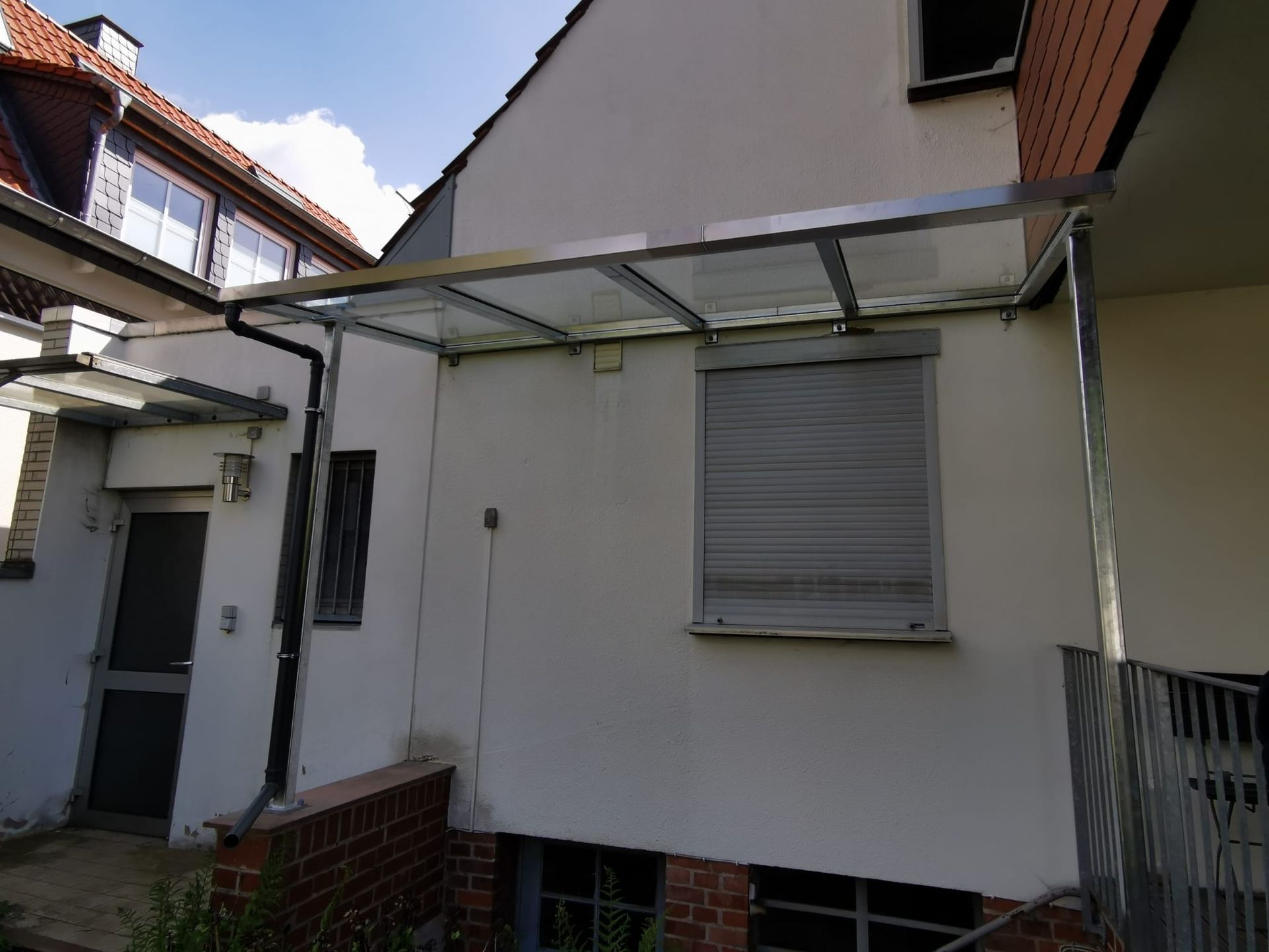 Ein weißes Gebäude mit einem Fenster und einem Vordach darüber