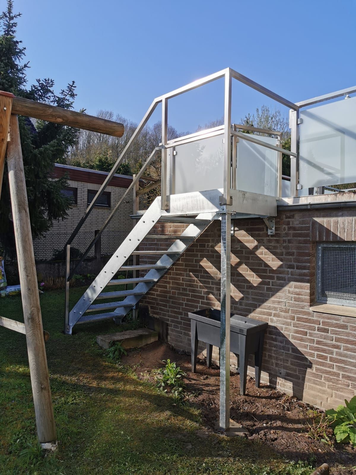 Eine Treppe, die zu einem Balkon an der Seite eines Backsteingebäudes führt.