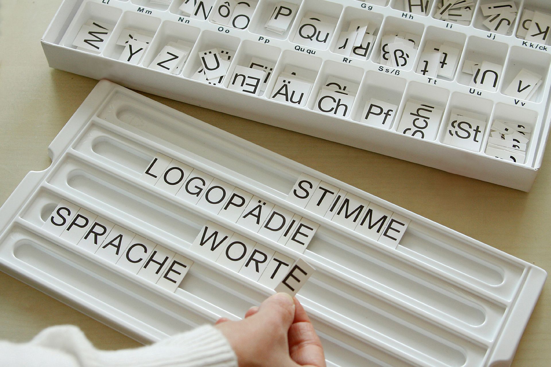 Eine Person hält ein weißes Tablett in der Hand, auf dem das Wort „Stimme“ steht