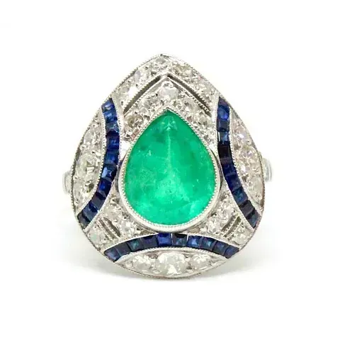 Un anillo con una esmeralda en forma de pera en el centro.